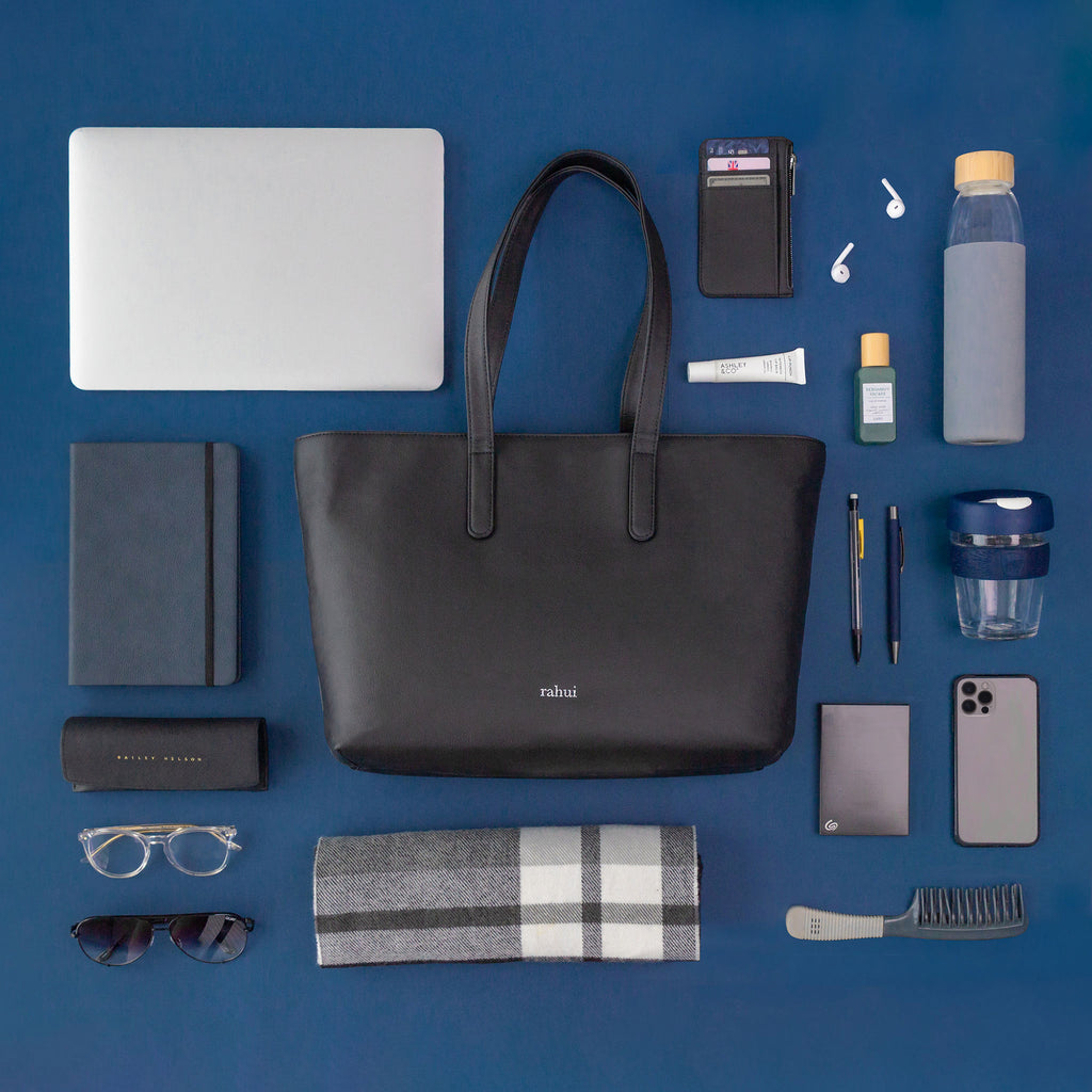 Top down view of Sequoia vegan Zip Tote and contents including laptop, cellphone, drink bottle,on a blue background