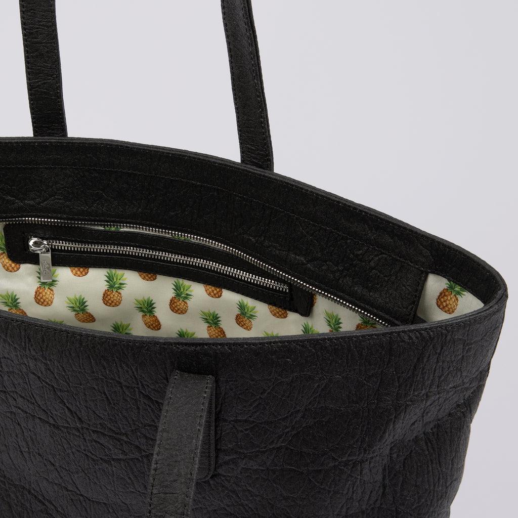 Inside view of textured black Rahui zip tote bag made from Pinatex Original on white background
