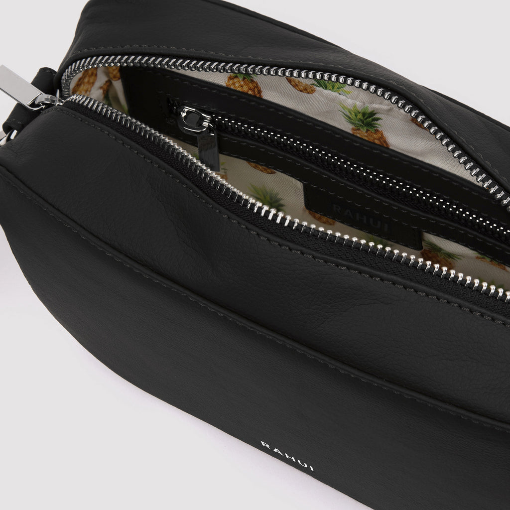 Inside view of black Rahui Crossbody bag made from apple leather on white background