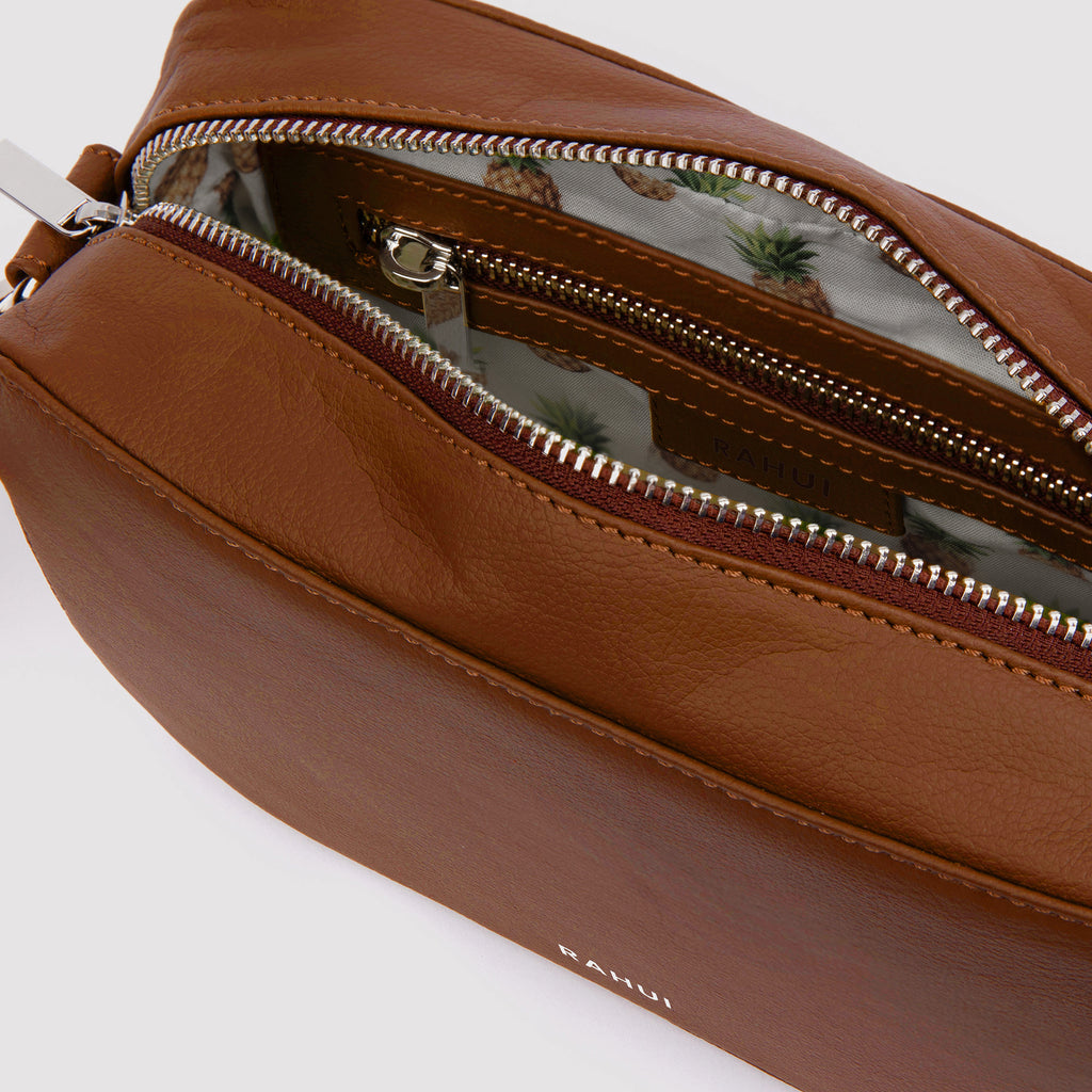 Inside view of tan Rahui Crossbody bag made from apple leather on white background