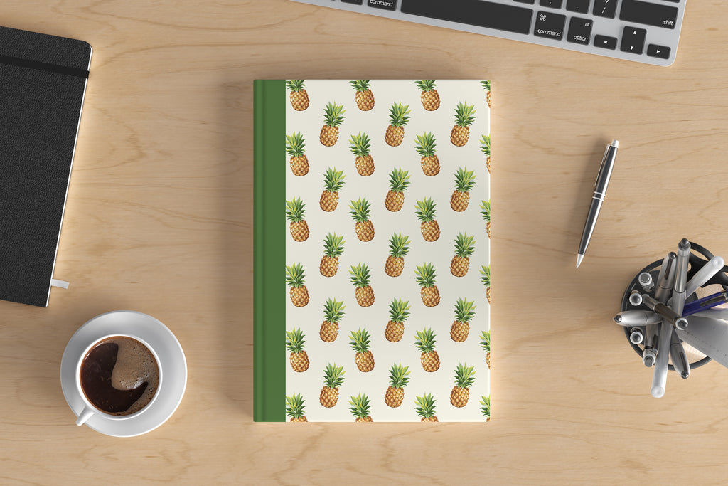 Pineapple lining print notebook next to coffee cup