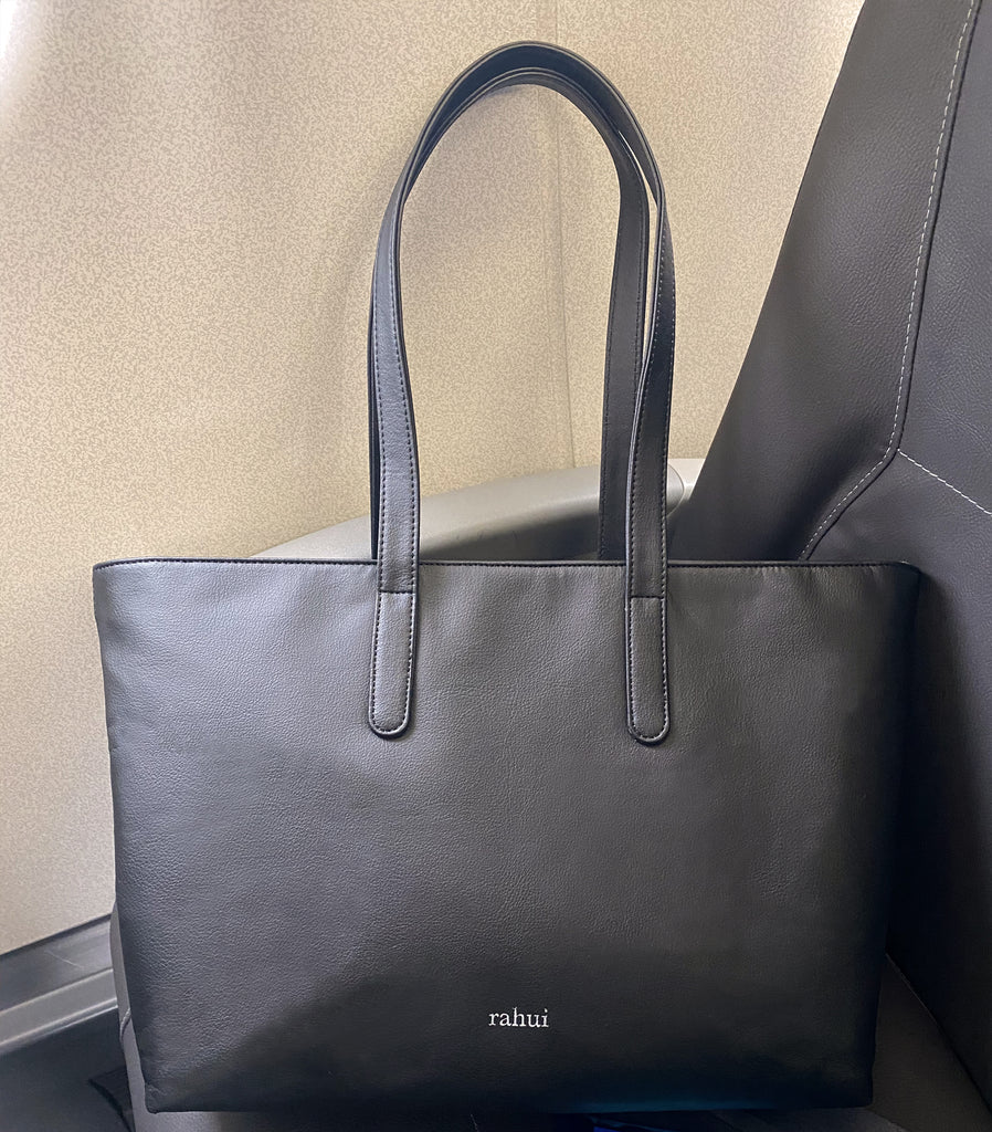 Customer image of black Rahui tote bag on airplane seat