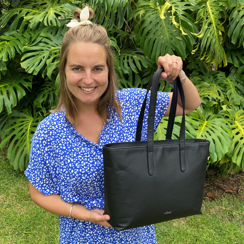Female customer smiling and holding out a Rahui Sequoia Zip Tote