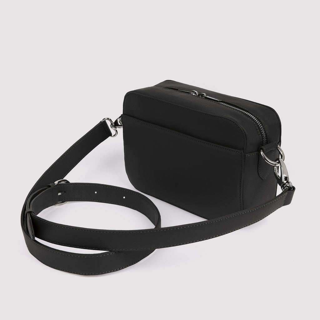 Side / angle view of black Rahui Crossbody bag made from apple leather on white background